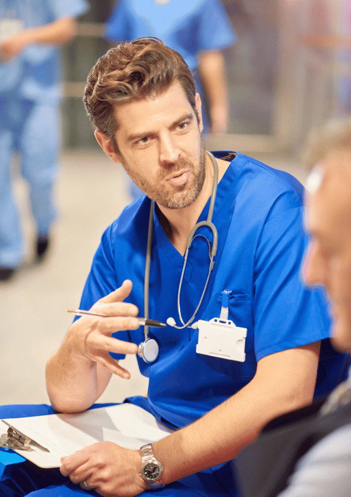 Male doctor in blue uniform talking to patient