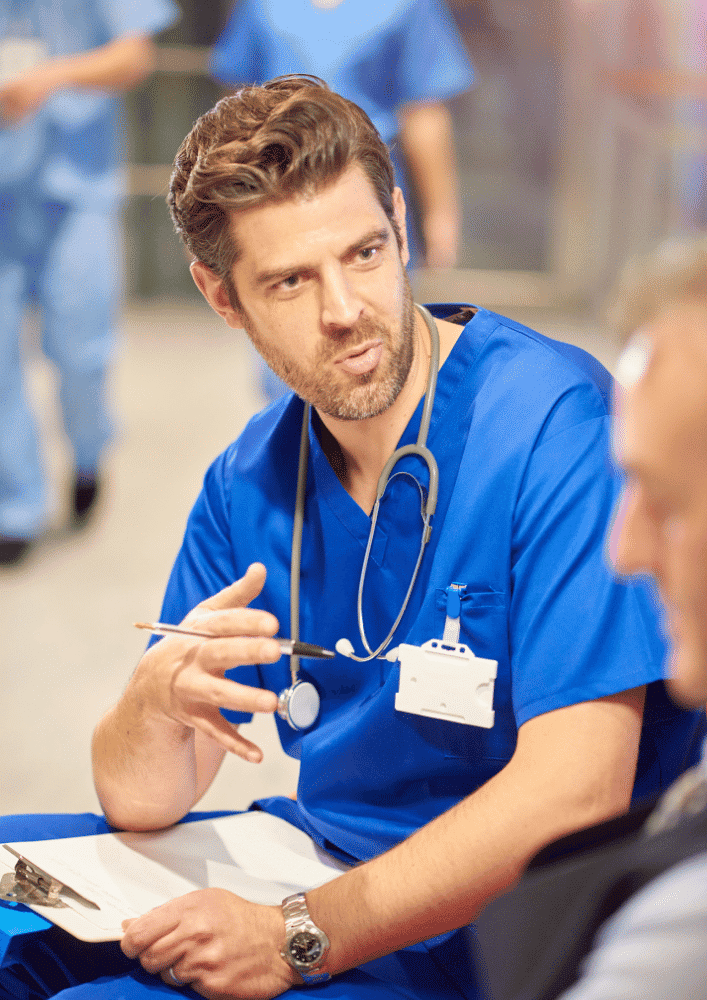 Male doctor in blue uniform talking to patient Male doctor in blue uniform talking to patient
