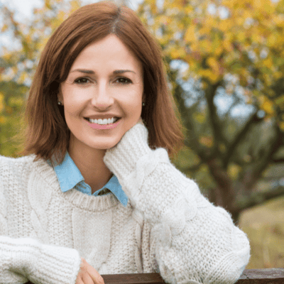 Smiling middle aged woman in a white sweater