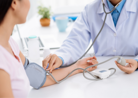 Doctor checking a female patient's blood pressure 